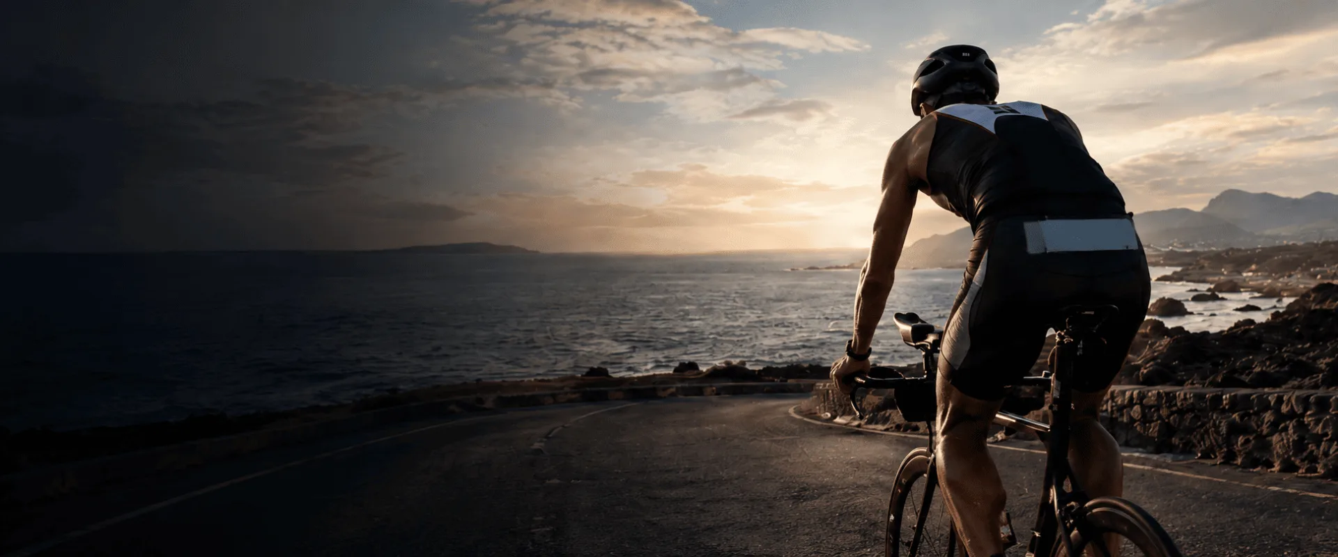 Triatleta rodando en bici junto al mar al amanecer